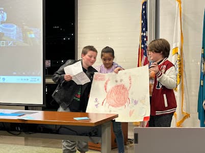 A team stands with their poster presentation
