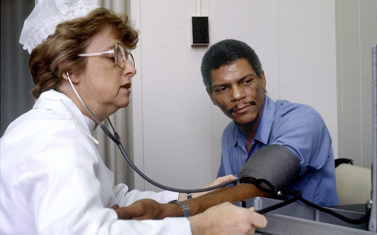 Medical assistant checking a patient's blood pressure in a calm clinic room