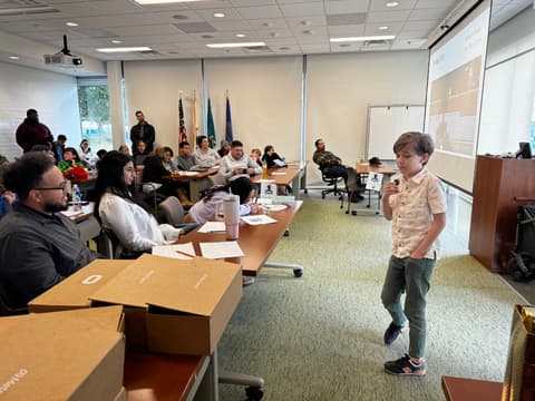 A student presents a game concept to judges