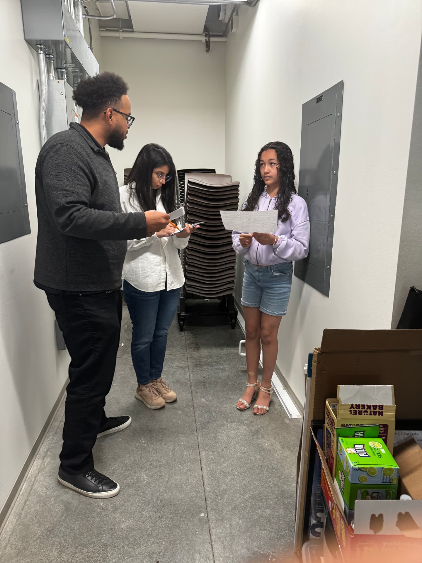 A BlackMuse instructor reviews notes with two students before they present