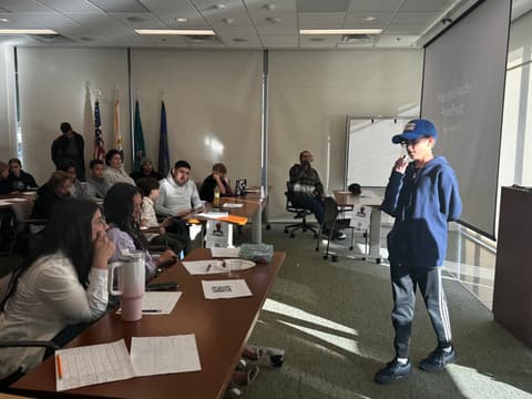 A student in a graduation cap presents an idea
