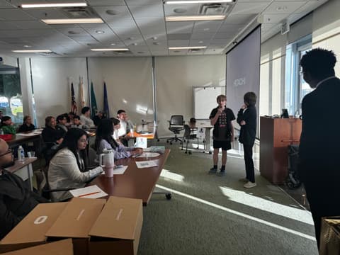A judge listens closely during a student pitch