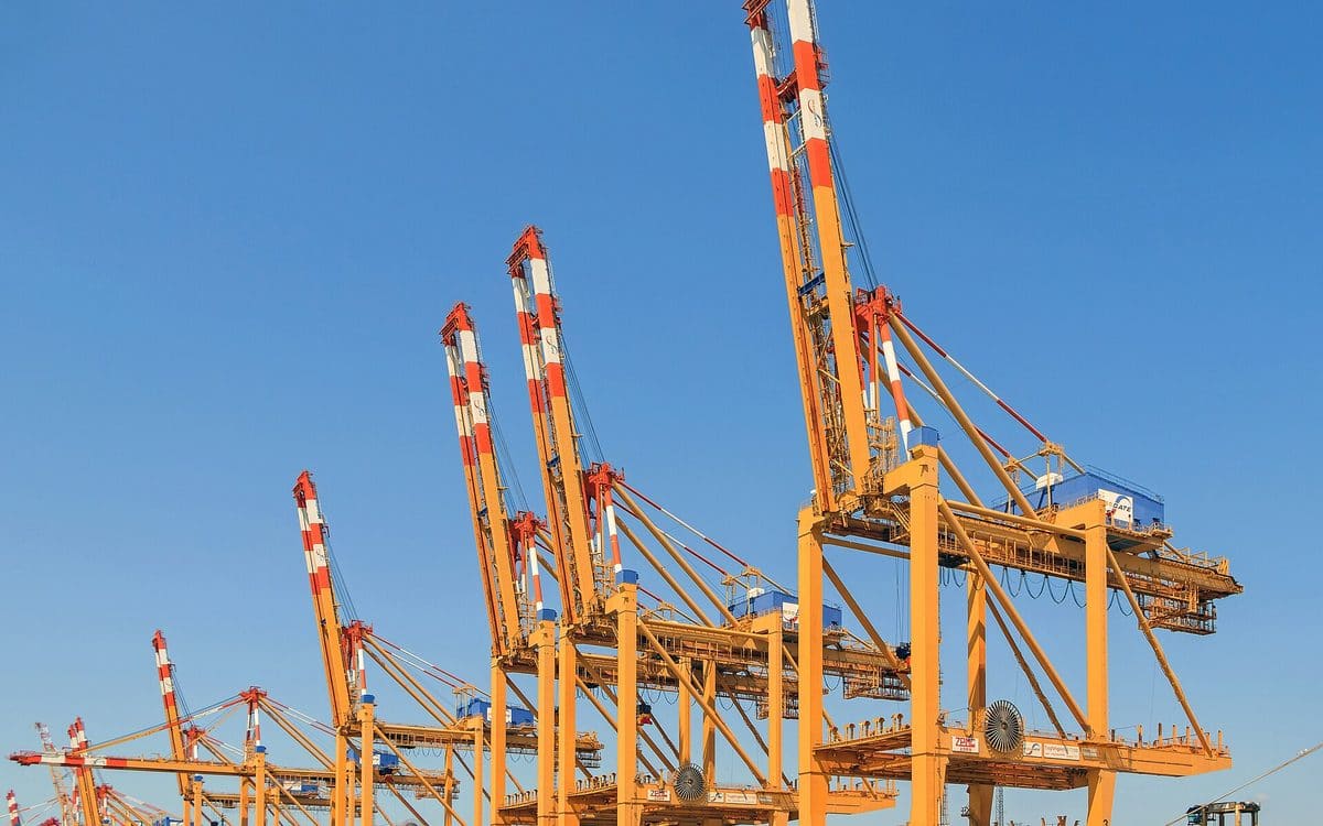 Container cranes loading cargo ships at a busy port terminal