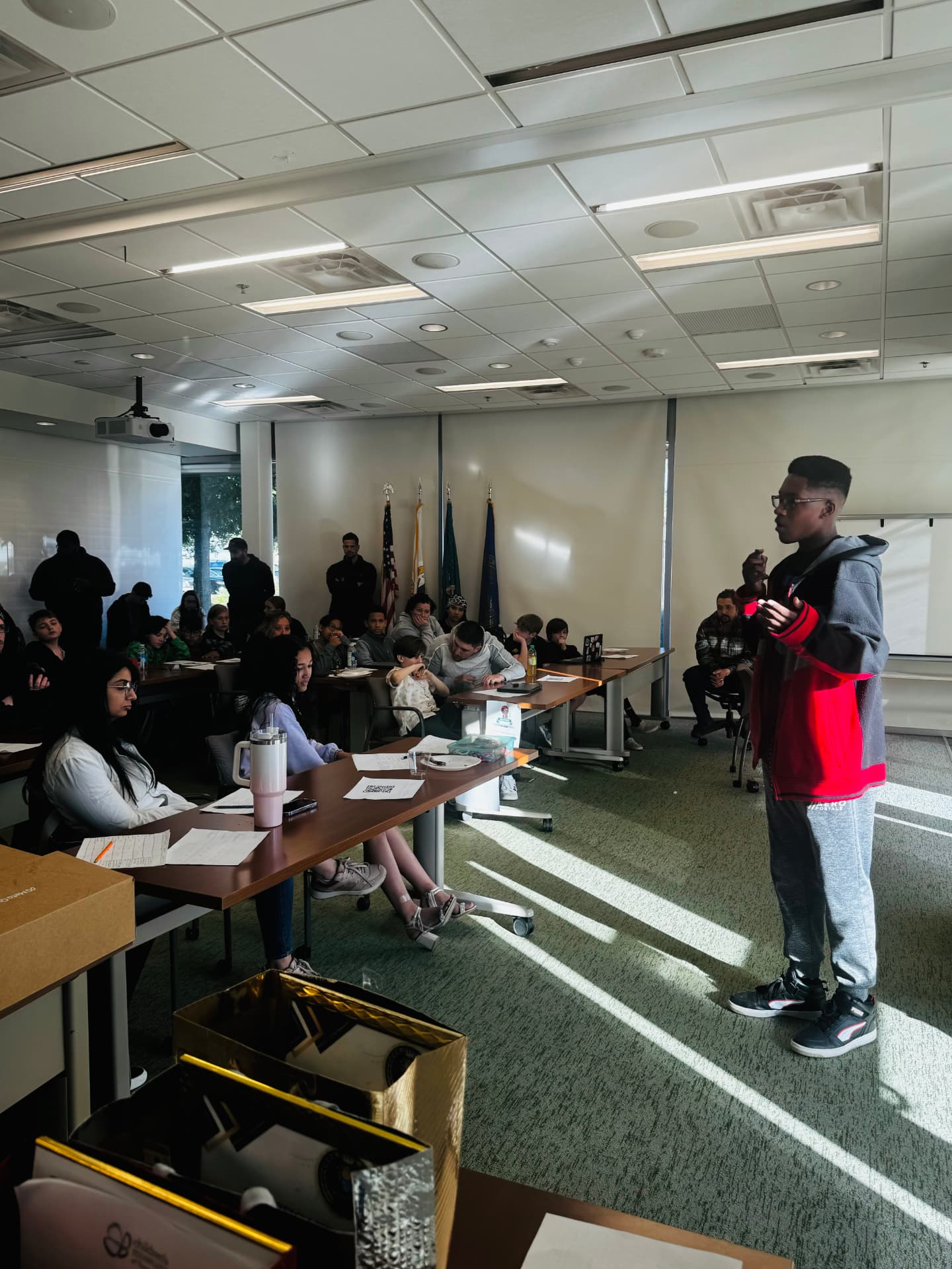 A student stands in front of the room and presents his idea to judges and classmates
