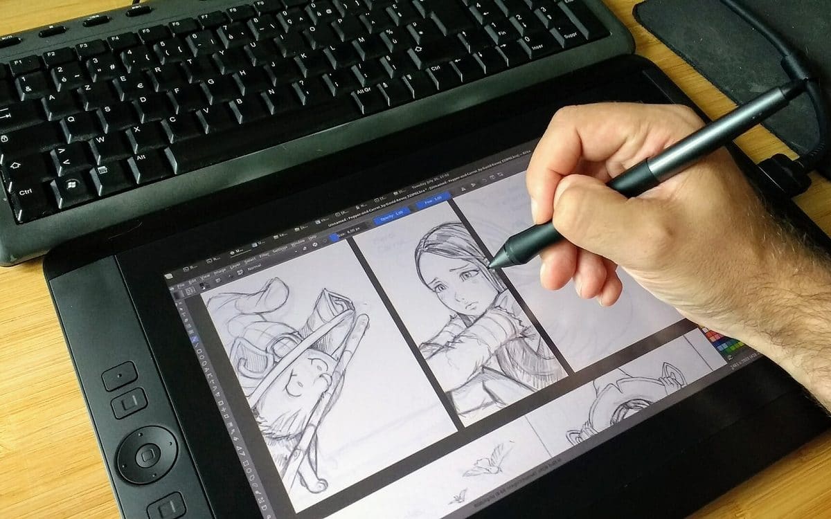 Illustrator inking a comic panel on a pen display with a stylus