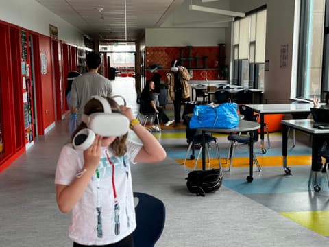 A student wearing a VR headset in a school hallway